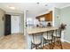 Bright kitchen featuring granite countertops, stainless steel sink, tile floors, and a breakfast bar with seating at 380 Three Lakes Ln # F, Venice, FL 34285