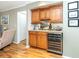 Living room with hardwood floors, a built-in bar, and a wine refrigerator at 380 Three Lakes Ln # F, Venice, FL 34285