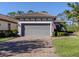 Two-car garage featuring a paved driveway and well-maintained landscaping at 5733 Semolino St, Nokomis, FL 34275