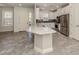 Open-concept kitchen with a center island, stainless steel appliances, and light tile flooring at 5733 Semolino St, Nokomis, FL 34275