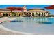 A luxurious swimming pool is showcased with an outdoor seating area and umbrellas at 12385 Amica Loop, Venice, FL 34293