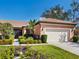 Charming single-story home featuring a clay tile roof, two-car garage, and vibrant landscaping at 1841 Batello Dr, Venice, FL 34292