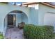 Inviting front entrance featuring an arched entryway, decorative shrubbery, and a cozy wicker chair at 507 Foxwood Blvd # 4, Englewood, FL 34223