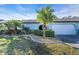 Well-manicured front yard with lush landscaping and a charming blue home exterior featuring a garage at 507 Foxwood Blvd # 4, Englewood, FL 34223