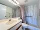 Bathroom with a tile shower, grab bars, and a wide mirror above the sink at 654 Bird Bay E Dr # 206, Venice, FL 34285