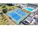 Aerial view of the community tennis courts, showcasing well-maintained blue courts and surrounding green space at 654 Bird Bay E Dr # 206, Venice, FL 34285