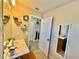 Bright bathroom featuring a large mirror, single sink vanity, updated lighting and a view into the Primary bedroom at 8307 Glover Ave, North Port, FL 34291