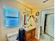 Well-lit bathroom featuring a large mirror, single sink vanity, updated lighting, and a window at 8307 Glover Ave, North Port, FL 34291