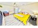 Bright bedroom with lots of natural light, ceiling fan, wood-look vinyl floors and cheerful yellow bedspread at 8307 Glover Ave, North Port, FL 34291