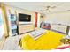 Bright bedroom with lots of natural light, ceiling fan, wood-look vinyl floors and cheerful yellow bedspread at 8307 Glover Ave, North Port, FL 34291