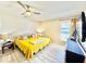 Bright bedroom with lots of natural light, ceiling fan, wood-look vinyl floors and cheerful yellow bedspread at 8307 Glover Ave, North Port, FL 34291