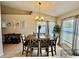 Cozy dining area featuring a wooden table set, chandelier lighting, and a large window providing ample natural light at 8307 Glover Ave, North Port, FL 34291