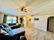 Bright living room featuring a large sectional sofa, ceiling fan, and laminate flooring at 8307 Glover Ave, North Port, FL 34291