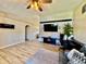 Open living room with a feature wall, a large screen TV, and vaulted ceilings at 8307 Glover Ave, North Port, FL 34291