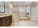 Elegant bathroom with soaking tub, glass shower, and granite countertops at 1206 Tuscany Blvd, Venice, FL 34292
