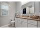 Bathroom featuring granite countertop, white cabinetry, and a large mirror at 1206 Tuscany Blvd, Venice, FL 34292