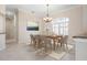 Bright dining room with a decorative chandelier, lots of light, and comfortable seating for six at 1206 Tuscany Blvd, Venice, FL 34292