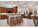 Spacious kitchen with counter seating, wooden cabinets, recessed lights and view to living area at 1206 Tuscany Blvd, Venice, FL 34292