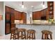 Well-equipped kitchen with wooden cabinetry, granite countertops, and barstool seating at 1206 Tuscany Blvd, Venice, FL 34292