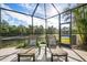 Screened lanai with lounge chairs overlooking a peaceful pond view at 1206 Tuscany Blvd, Venice, FL 34292