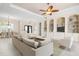 Open-concept living room with a ceiling fan, built-in shelving, and neutral decor throughout at 1206 Tuscany Blvd, Venice, FL 34292