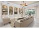 Bright living room with tile floors, built-in bookshelves, and sliding glass doors to the patio at 1206 Tuscany Blvd, Venice, FL 34292