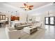 Open-concept living room with tile flooring, modern decor, and access to the kitchen and dining areas at 1206 Tuscany Blvd, Venice, FL 34292