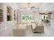 Bright living room with built-in shelving, neutral color palette, and sliding glass doors at 1206 Tuscany Blvd, Venice, FL 34292