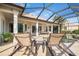 Screened-in patio area with outdoor seating, columns, and a partial pool view at 1206 Tuscany Blvd, Venice, FL 34292