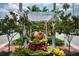 Picturesque water feature framed by a white pergola and vibrant flowers, enhancing the beauty of the neighborhood at 1206 Tuscany Blvd, Venice, FL 34292