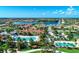 Aerial view of a community with pool, clubhouse, lake, and mature landscaping on a sunny day at 13364 Dimarco St, Venice, FL 34293