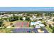 Aerial view of community tennis courts, clubhouse, and surrounding homes in a lush, landscaped neighborhood at 1815 Killdeer Ct, Venice, FL 34293