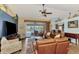 Comfortable living room with plush leather seating, a ceiling fan, and a view of the pool and waterfront at 1815 Killdeer Ct, Venice, FL 34293