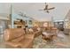 Open-concept living room with comfortable leather seating that connects to the kitchen and dining area at 1815 Killdeer Ct, Venice, FL 34293