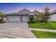 Beautiful single-story home with a paved driveway, a three-car garage, and attractive landscaping at 19807 Bridgetown Loop, Venice, FL 34293