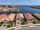 Beautiful aerial view of waterfront homes with brick driveways, lush landscaping, and tile roofs in a Florida community at 232 Teramo Way, Nokomis, FL 34275