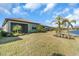 Manicured backyard landscaping near a waterfront property with palm trees, offering tranquil scenery at 232 Teramo Way, Nokomis, FL 34275