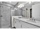 Bathroom features a double sink vanity with granite countertop, large mirror, and walk-in shower with glass door at 232 Teramo Way, Nokomis, FL 34275
