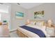 This bedroom features a rattan bed frame and furnishings, soothing beach art and decor, and wood floors at 232 Teramo Way, Nokomis, FL 34275