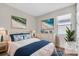 This bedroom offers a large bright window, soothing beach art and decor, and a white woodgrain dresser and bedside tables at 232 Teramo Way, Nokomis, FL 34275
