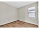 A clean and bright bedroom with a large window with blinds and beautiful hard wood floors at 232 Teramo Way, Nokomis, FL 34275