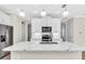 Close up of kitchen island with a white countertop with grey veining, stainless sink, and pendant lighting at 232 Teramo Way, Nokomis, FL 34275