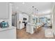 Open kitchen boasts white cabinetry, stainless appliances, large island, and flows into the dining and living area at 232 Teramo Way, Nokomis, FL 34275