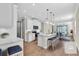 This open kitchen with white cabinets has stainless appliances and a center island that connects to the dining area at 232 Teramo Way, Nokomis, FL 34275