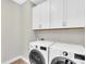 Well-equipped laundry area featuring modern appliances, including a washer, dryer, and overhead cabinets at 232 Teramo Way, Nokomis, FL 34275