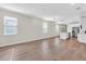 Spacious living room featuring wood floors, large windows, and an open layout to the kitchen at 232 Teramo Way, Nokomis, FL 34275