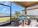 Screened patio with a glass-top table and seating, providing a beautiful outdoor dining space with lake views at 232 Teramo Way, Nokomis, FL 34275