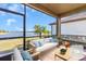 Relaxing screened-in patio with comfortable seating, offering serene views of the lake and landscaping at 232 Teramo Way, Nokomis, FL 34275