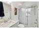 Clean white bathroom featuring a shower-tub combo with glass doors, marble countertop, and neutral decor at 5800 Sabal Trace Dr # 501, North Port, FL 34287