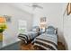 Bright bedroom featuring two twin beds with matching blue and white striped bedding, and white ceiling fan at 5800 Sabal Trace Dr # 501, North Port, FL 34287